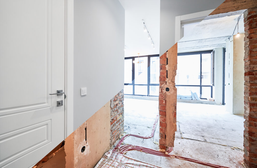 Ancien appartement aux murs en briques et logement rénové avec portes modernes et design élégant aux tons blancs. Intérieur avant et après rénovation.