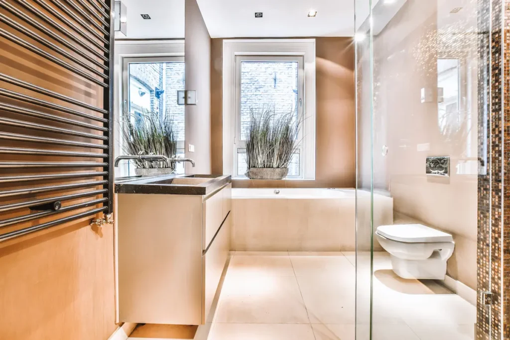 Intérieur d’une petite salle de bain à Levallois Perret propre et lumineuse, aux tons chauds et apaisants, pensée pour optimiser l’espace tout en offrant une atmosphère chaleureuse et élégante. DTP Rénovation